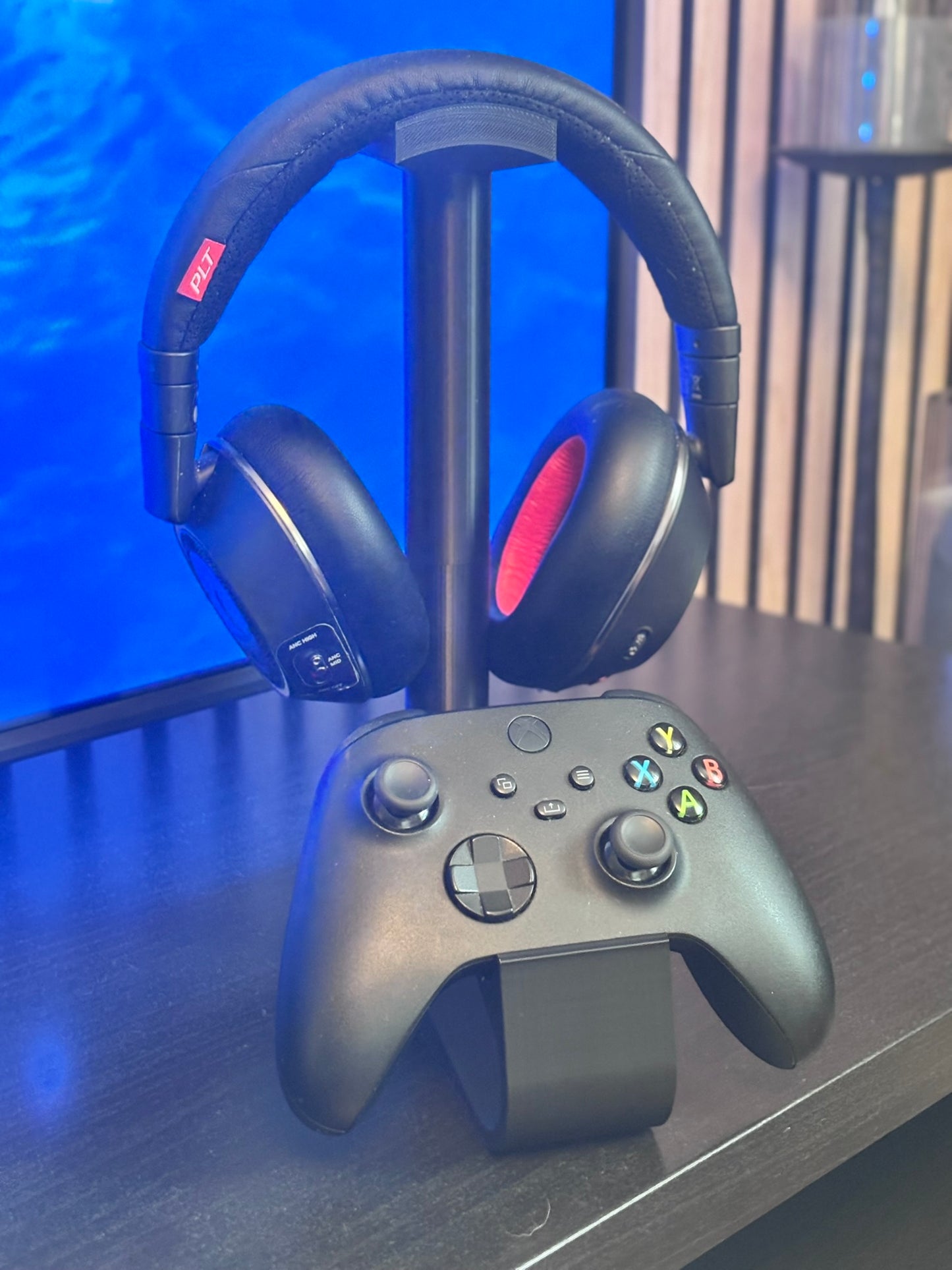 Bordsstativ för PS5 och Xbox-kontrollers med gaming-headset, organiserad gaming setup