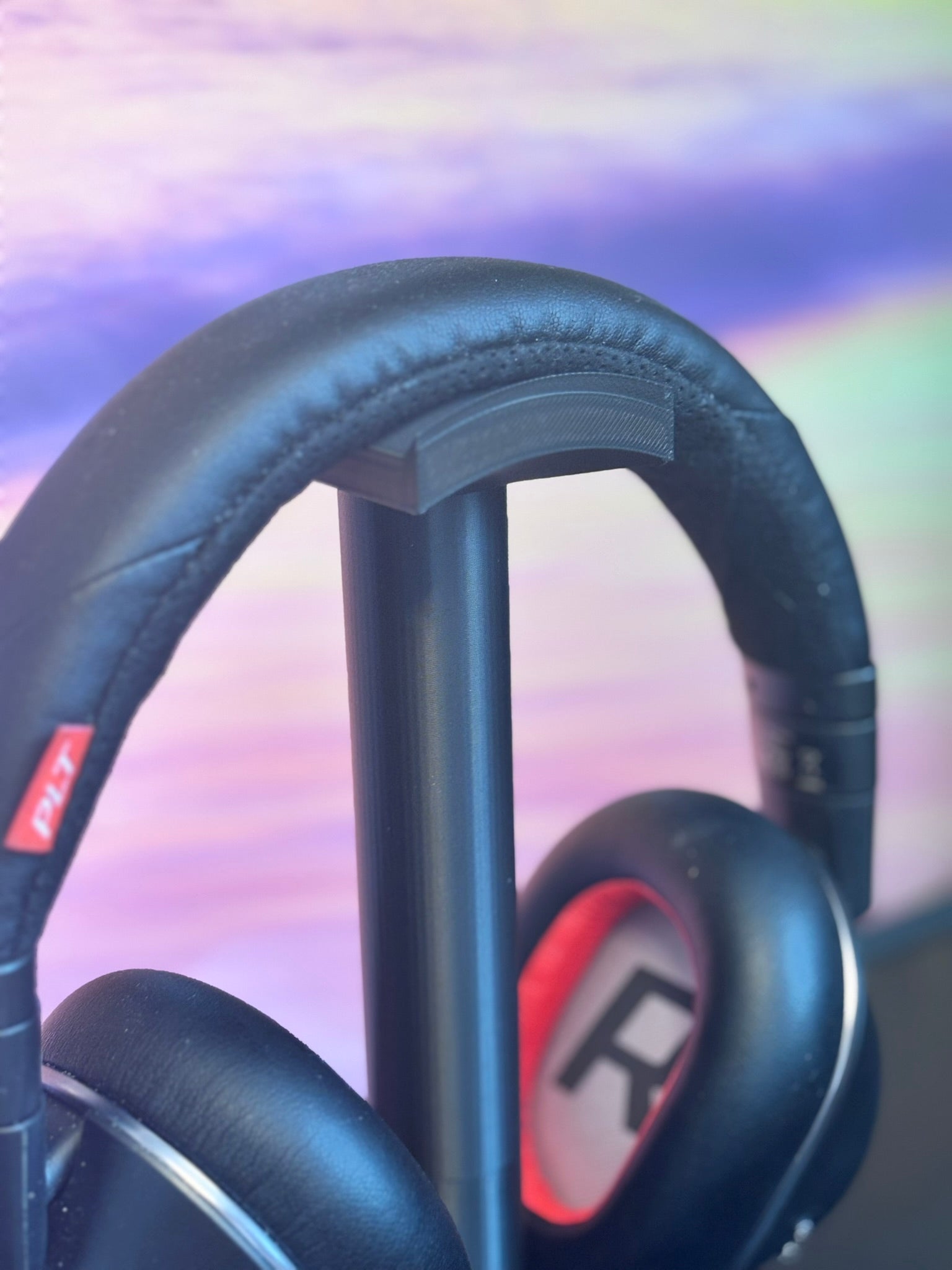 Gaming headset on a sleek stand with a colorful gradient background.